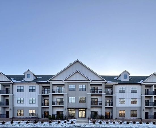 A large, multi-story residential building with a flat roof and multiple balconies.