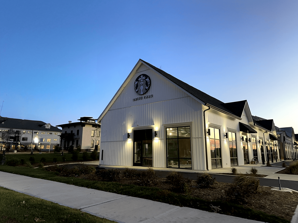 A Starbucks building is lit up at dusk.