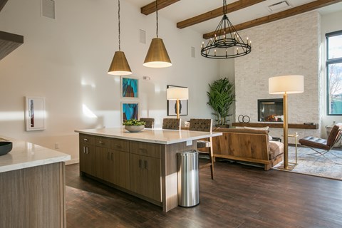 A modern kitchen with a wooden island and pendant lights.