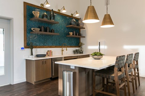 A kitchen with a large island and wooden chairs.