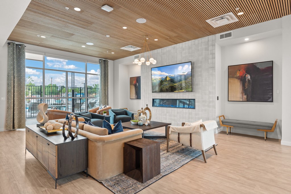A modern living room with a wooden ceiling and a large window.