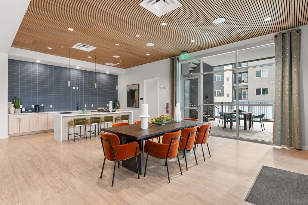 A modern dining room with a long table and chairs.