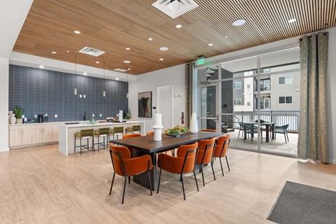 A modern dining room with a long table and chairs.