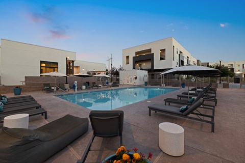 A modern poolside area with lounge chairs and a pool.