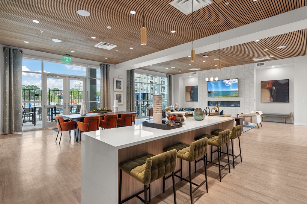A modern kitchen with a bar area and a view of the outdoors.