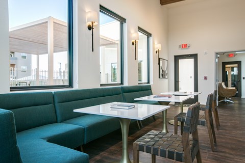 A white table with a green couch and chairs in front of a window.