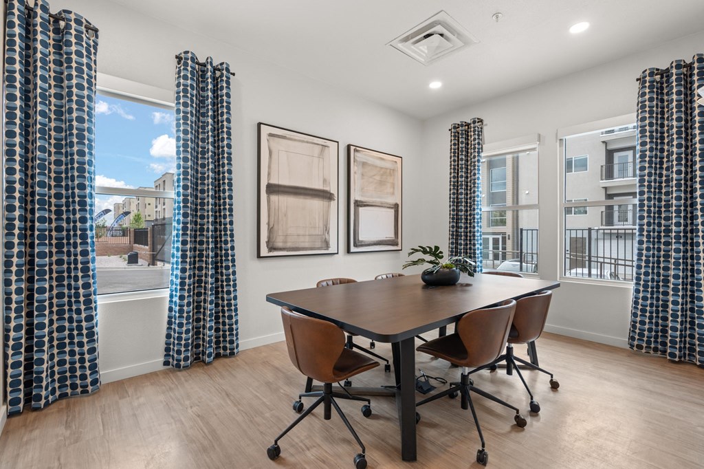 A conference room with a table, chairs and pictures on the wall.