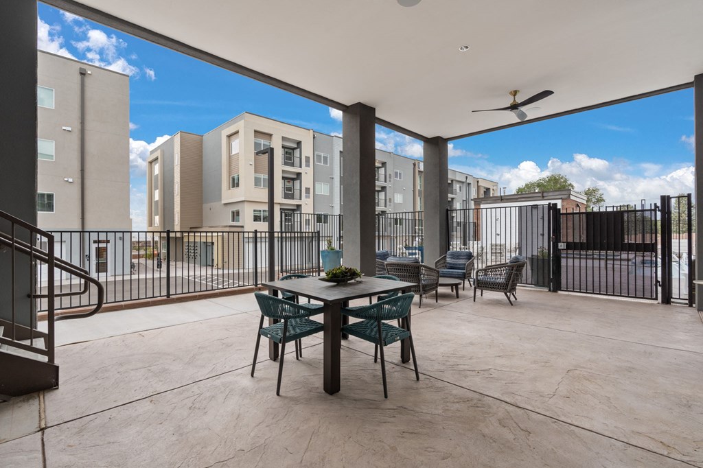 A patio with a table and chairs overlooks a cityscape.
