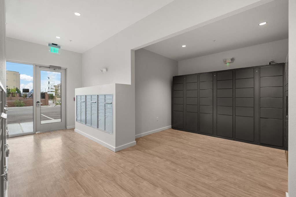 A room with wooden floors and a large window with a view of the street.