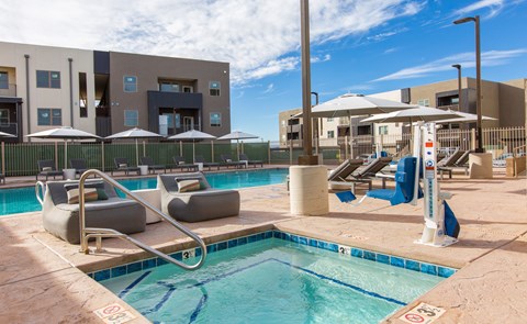 A pool with a slide and sun loungers.