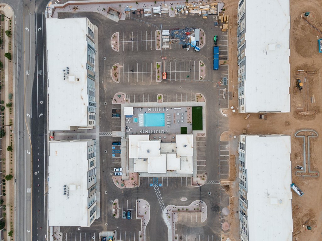 A parking lot with a pool and a building in the background.