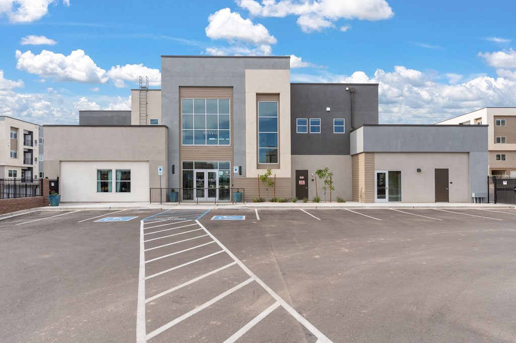A modern building with a parking lot in front.