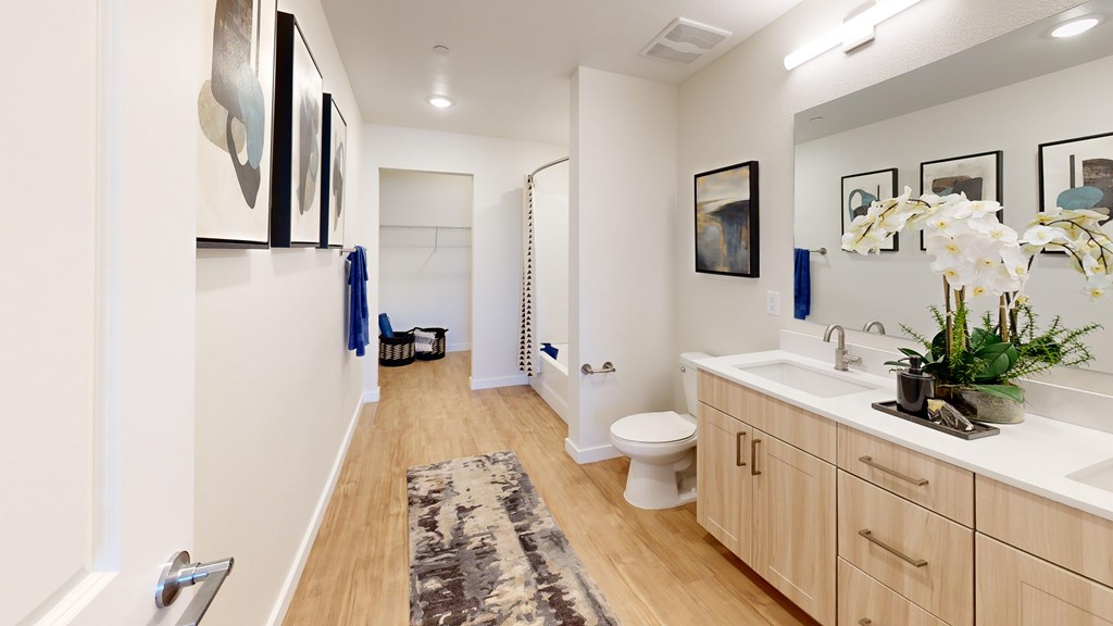 A bathroom with a toilet, sink, and mirror.