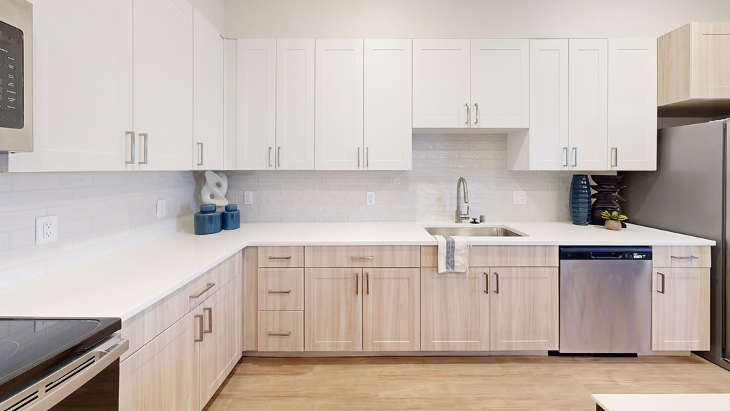 A kitchen with white cabinets and a wooden floor.