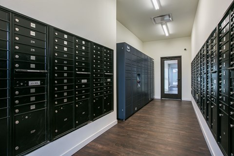 A long hallway with black mailboxes on either side.