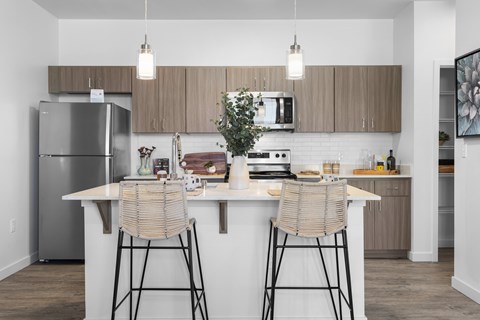 A modern kitchen with a white countertop and wooden cabinets.