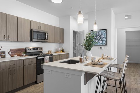 A modern kitchen with a dining table set for two.