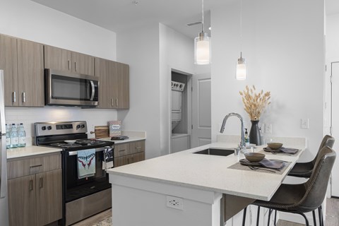 A modern kitchen with a white island and dark brown cabinets.