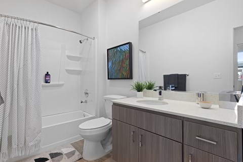 A bathroom with a toilet, sink, and shower.