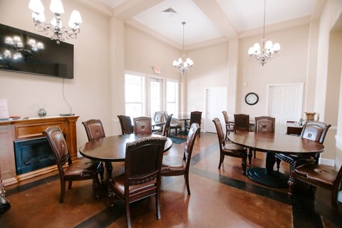 A dining room with a large table and chairs.