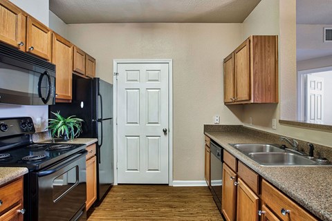 A kitchen with wooden cabinets and a black stove top oven.