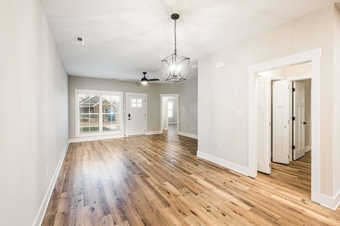 A spacious room with wooden floors and white walls.