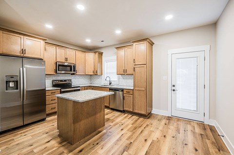 A kitchen with wooden cabinets and a wooden island.