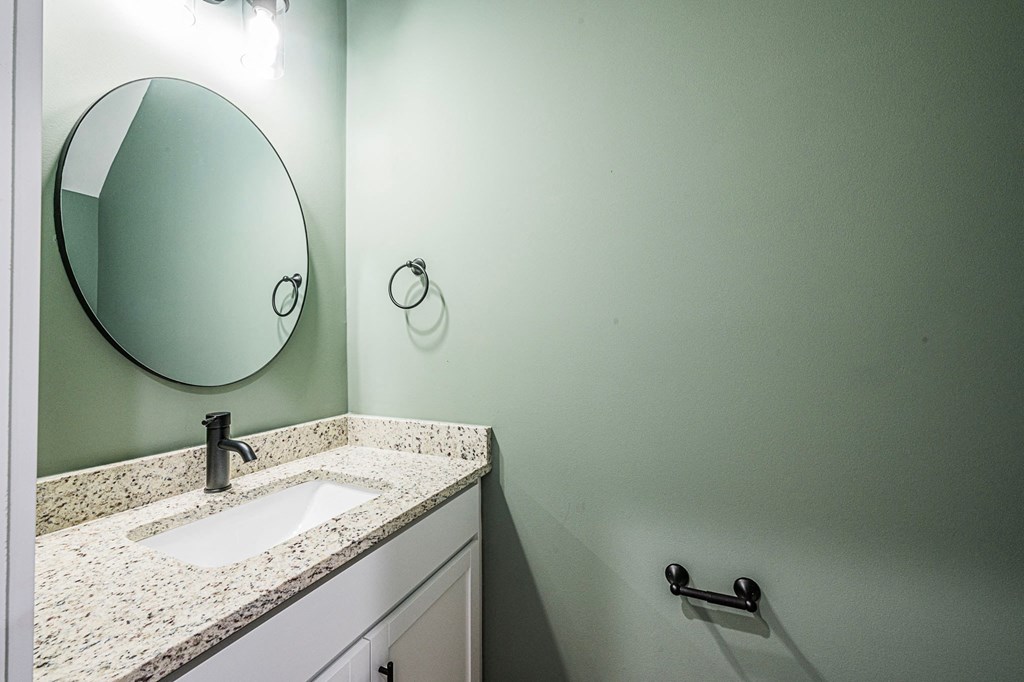 A bathroom with a sink and a mirror.