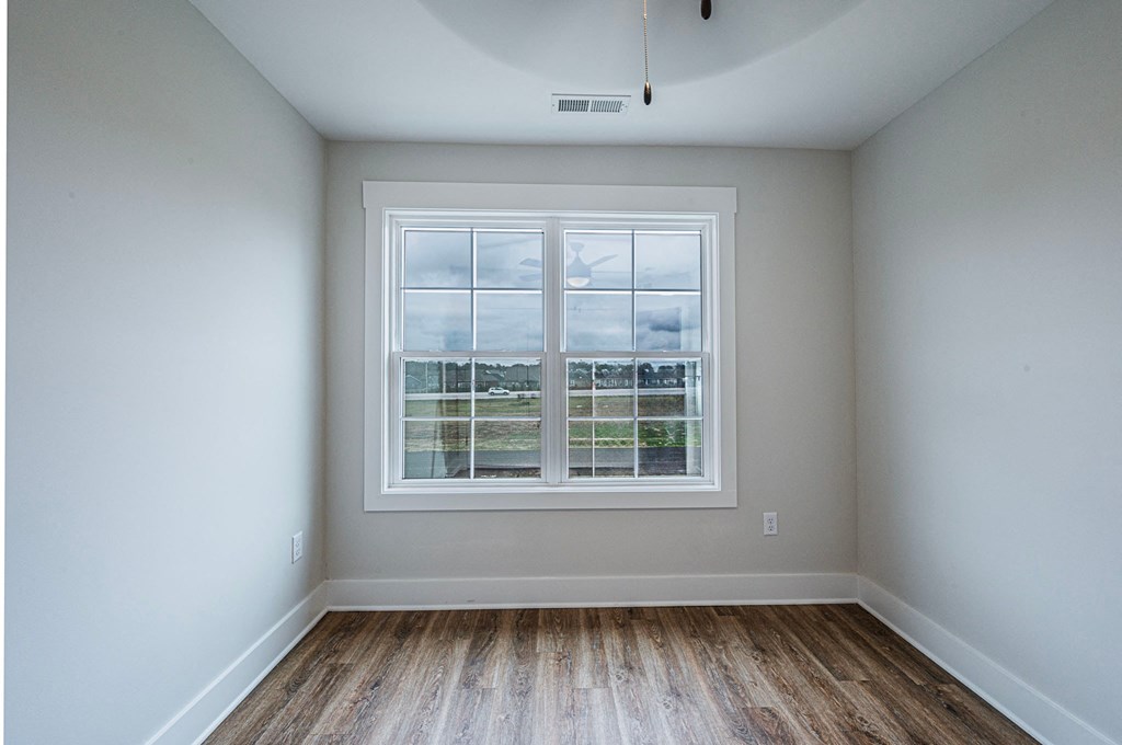A room with a window and wooden flooring.