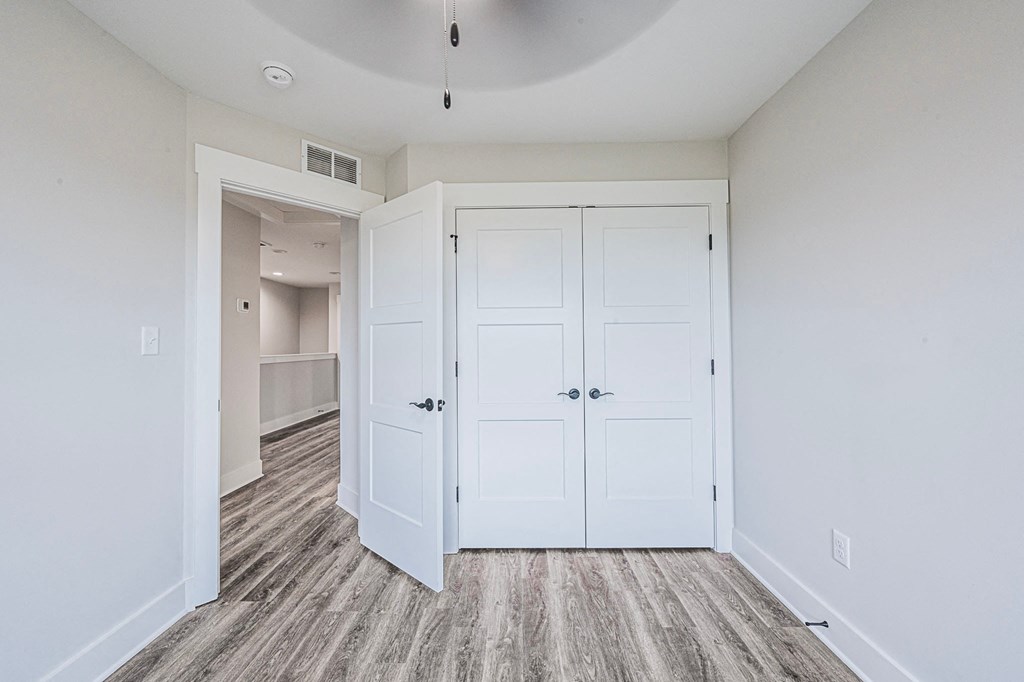 A room with a white door and a grey floor.