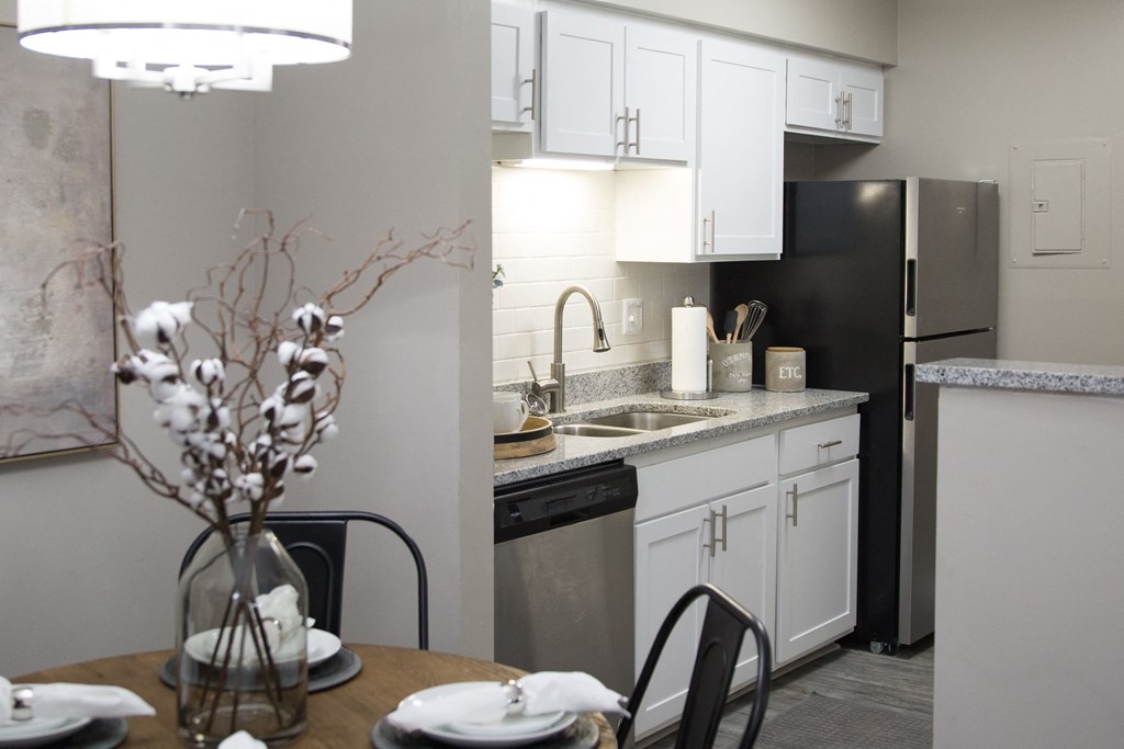 a kitchen with white cabinets and black appliances