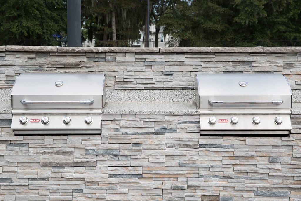two stainless steel grills on a stone wall