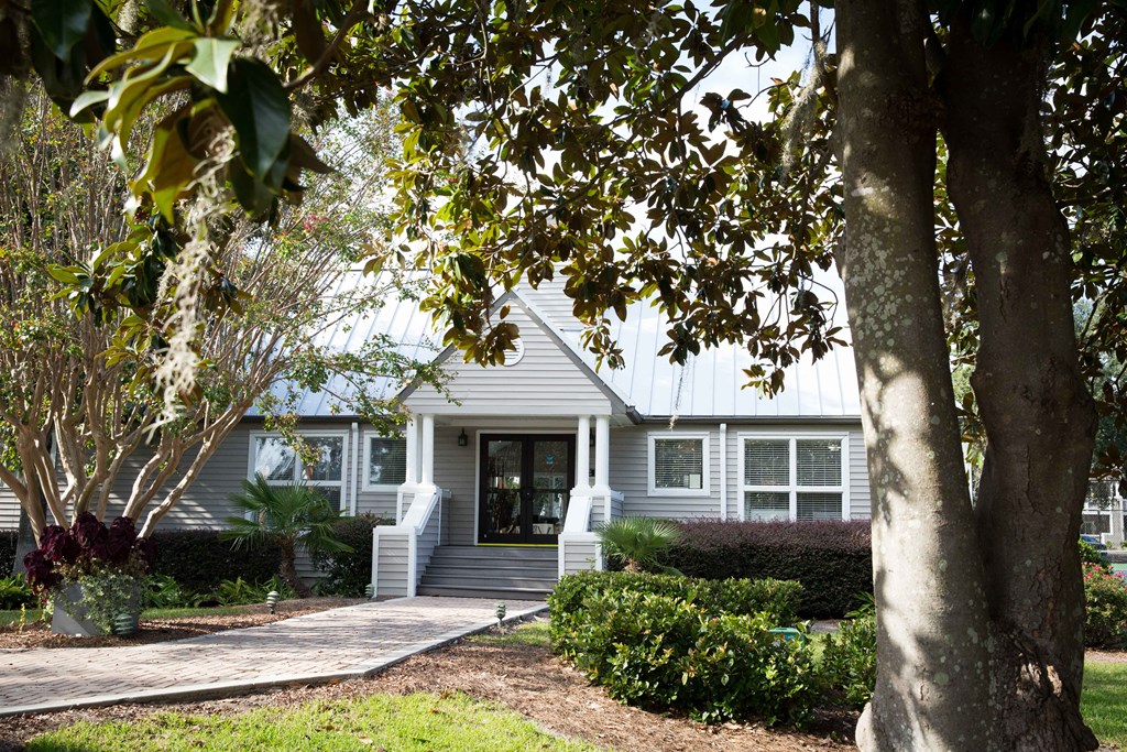 a white house with a front porch and a tree