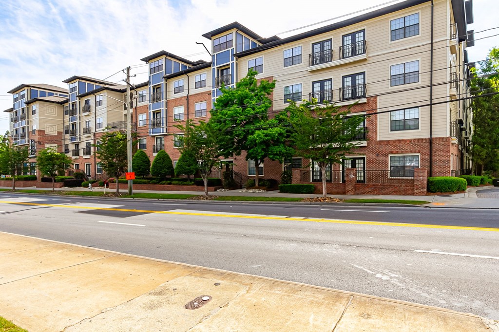 an empty street with an apartment building on the corner
