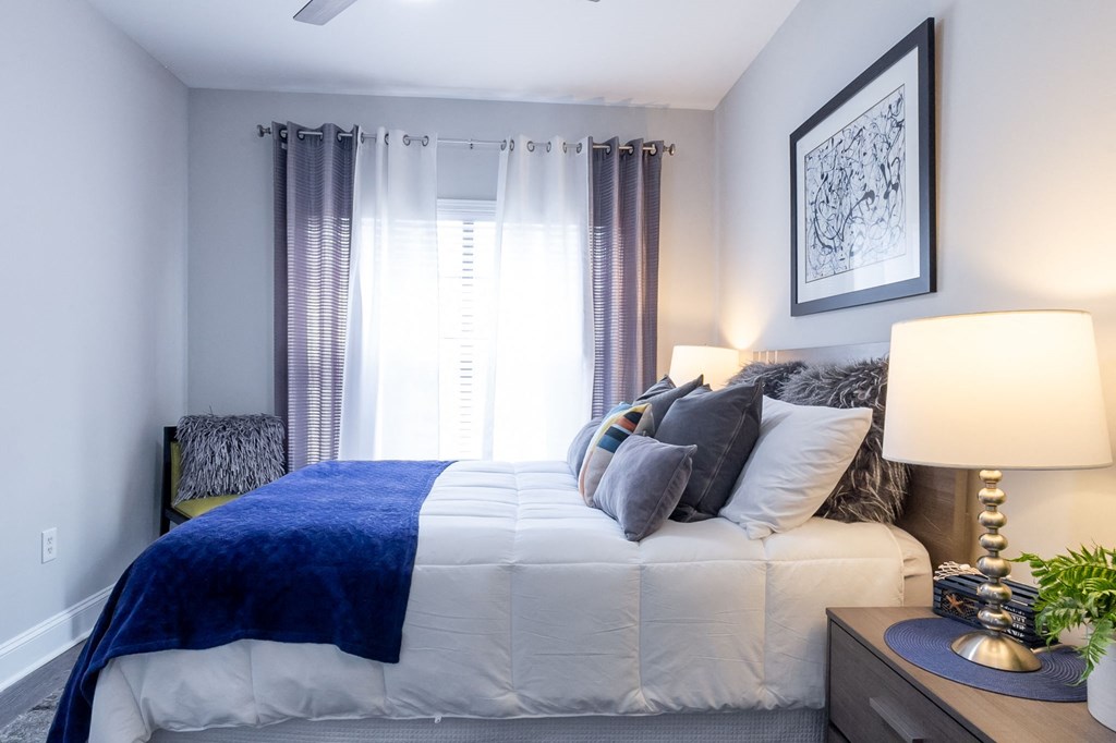 a bedroom with a large white bed and a blue blanket