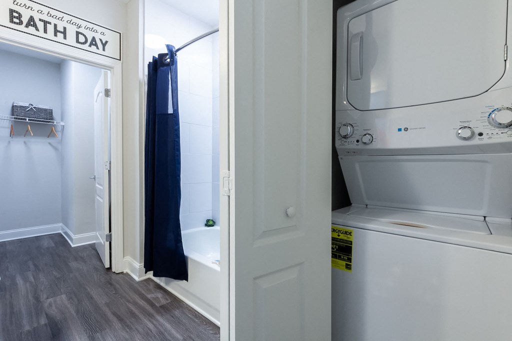 a laundry room with a washer and dryer and a door to a bathroom
