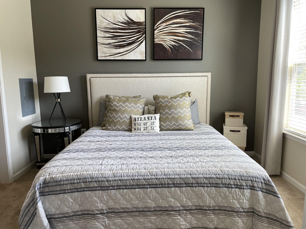 a bedroom with a bed and two paintings on the wall