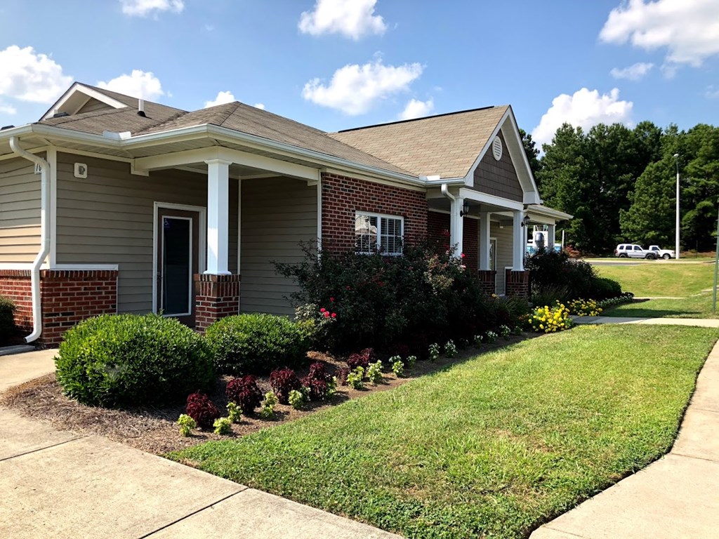 a house with a lawn and bushes in front of it