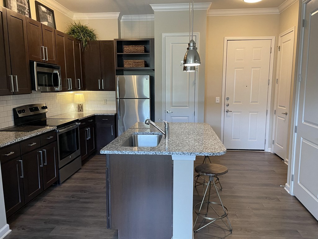 a kitchen with dark cabinets and a granite counter top