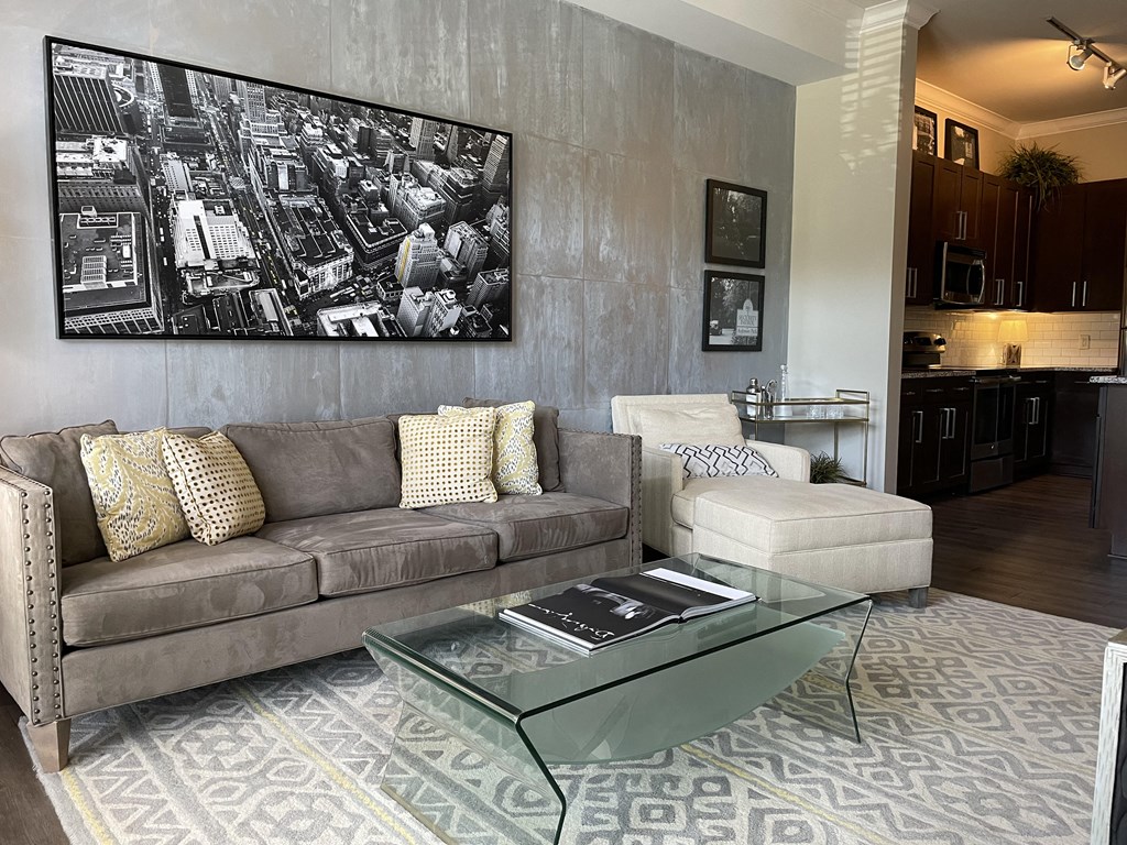 a living room with a couch coffee table and a kitchen in the background