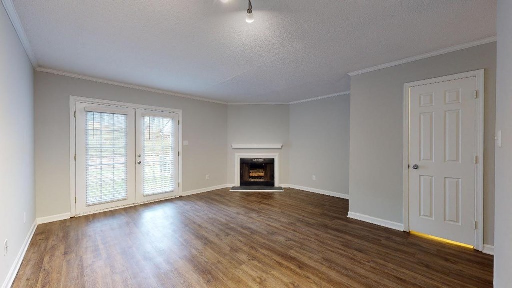 an empty living room with wood floors and a fireplace