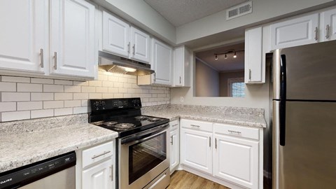 a kitchen with white cabinets and stainless steel appliances