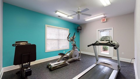 a home gym with a turquoise wall and exercise equipment