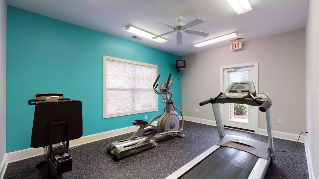 a home gym with a turquoise wall and exercise equipment