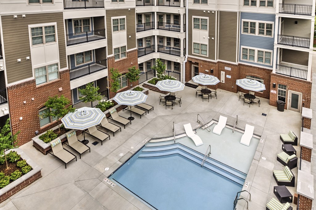 an aerial view of an apartment complex with a pool and patio furniture