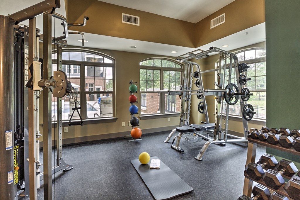 a gym with weights and other exercise equipment and windows