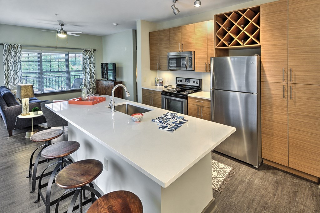 a kitchen with a large island and a stainless steel refrigerator