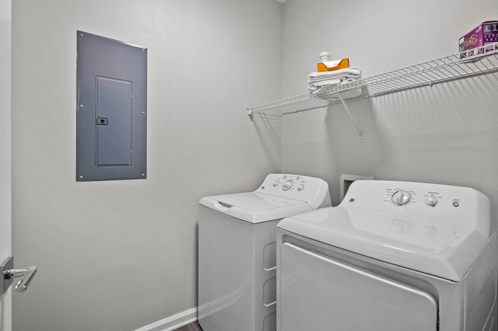 a washer and dryer in a white laundry room with a blue door
