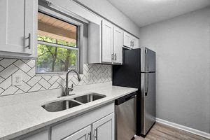 a kitchen with a sink a refrigerator and a window