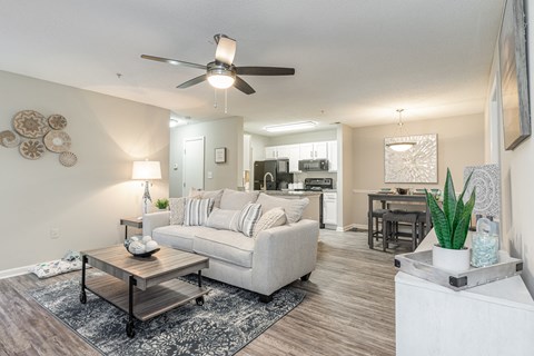 A living room with a white couch and a ceiling fan.
